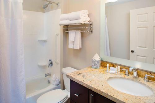 嘉年TownePlace Suites by Marriott Phoenix Goodyear的一间带水槽、卫生间和镜子的浴室