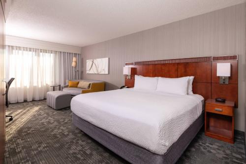纽瓦克特拉华州纽瓦克大学万怡酒店 的酒店客房带一张大床和一把椅子