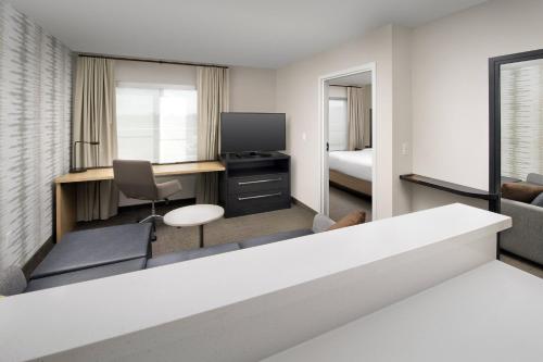 莫德斯托Residence Inn by Marriott Modesto North的配有书桌和电视的酒店客房