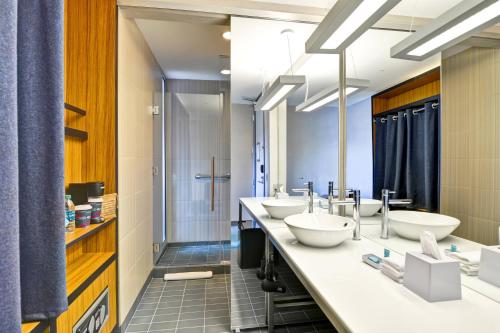 凤凰城菲尼克斯机场雅乐轩酒店的一间带三个盥洗盆和淋浴的浴室