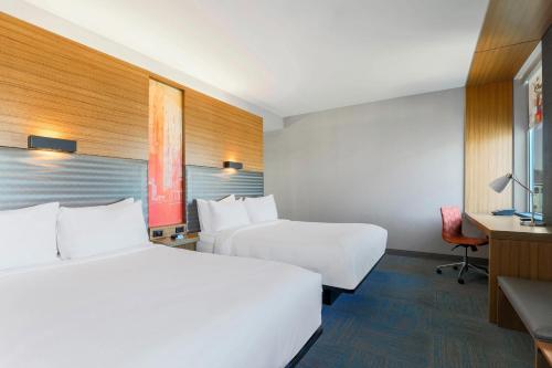 凤凰城菲尼克斯机场雅乐轩酒店的酒店客房配有两张床和一张书桌