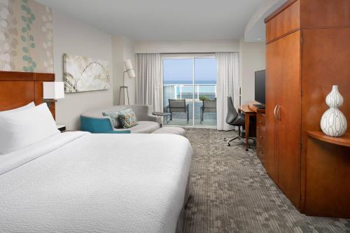 大洋城海洋城海滨万怡酒店的酒店客房配有一张床、一张书桌和一台电视。