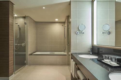 新山Renaissance Johor Bahru Hotel的一间带两个盥洗盆和淋浴的浴室