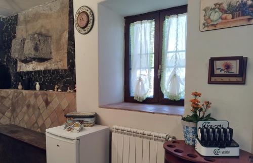 PuntalazzoVilla Alessio - Case Vacanza con Piscina sull'Etna的客房设有冰箱、窗户和散热器