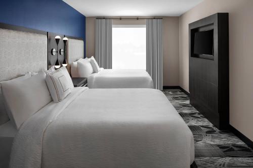 里士满Residence Inn Richmond Midtown/Glenside的酒店客房设有两张床和电视。