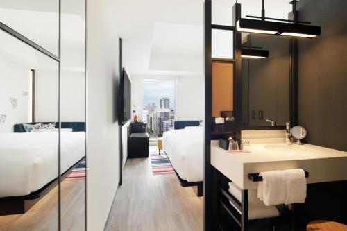东京Aloft Tokyo Ginza的一间带水槽、床和镜子的浴室