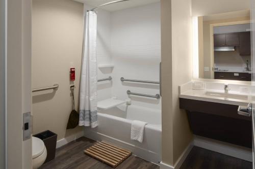 坦帕TownePlace Suites by Marriott Tampa South的一间带水槽、卫生间和镜子的浴室