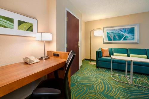 南本德SpringHill Suites Mishawaka-University Area的酒店客房配有书桌和沙发。