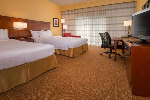威廉斯堡威廉斯堡布希花园万怡酒店的酒店客房设有两张床和一张书桌及电视