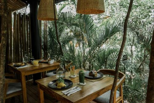 图卢姆Copal Tulum Hotel的一张木桌,上面放着食物盘