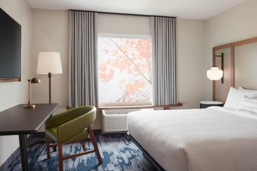 路易斯威尔Fairfield by Marriott Inn & Suites Louisville Shepherdsville的配有一张床、一张书桌和一扇窗户的酒店客房