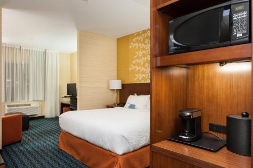 弗农Fairfield Inn & Suites by Marriott Vernon的配有一张床和一台平面电视的酒店客房