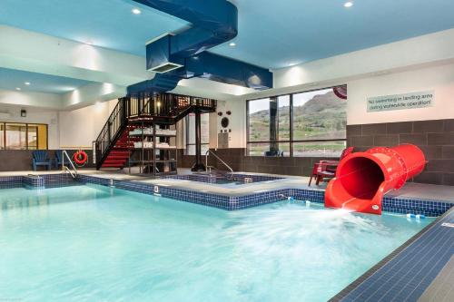 弗农Fairfield Inn & Suites by Marriott Vernon的大楼内一个带红色滑梯的大型游泳池