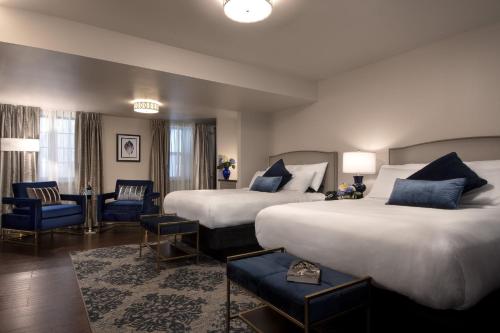 圣路易斯七阁楼旅馆的酒店客房,配有两张床和蓝色椅子