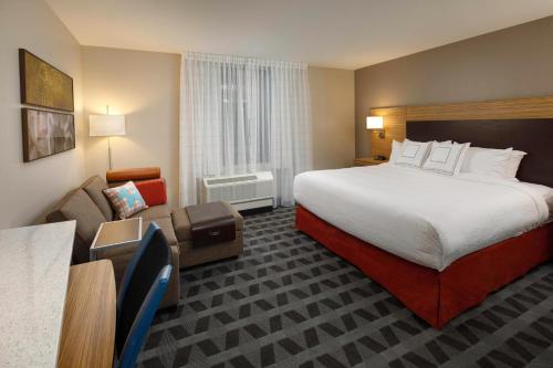 路易斯威尔Towneplace Suites By Marriott Louisville Northeast的酒店客房设有一张大床和一张沙发。