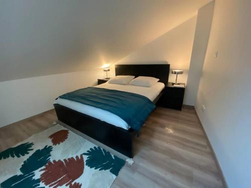 希尔蒂盖姆Duplex By Aurelle 2-Wifi-10 mn centre Strasbourg- proche Parlement Européen的一间卧室配有一张带绿毯的大床