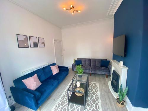 布莱克浦Manchester House的客厅设有蓝色的沙发和壁炉