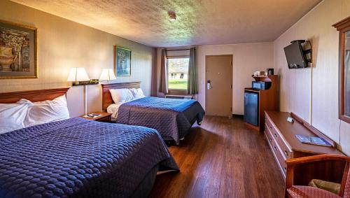 新坎伯兰Magnuson Grand Harrisburg的酒店客房设有两张床和电视。