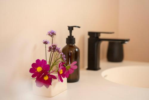 格雷敦The Castle的浴室柜台上的一瓶肥皂和鲜花