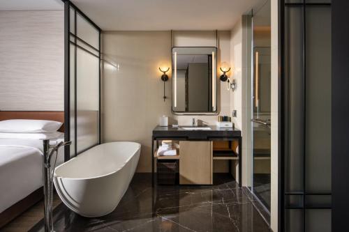 象山宁波象山绿城喜来登度假酒店的带浴缸和盥洗盆的酒店浴室