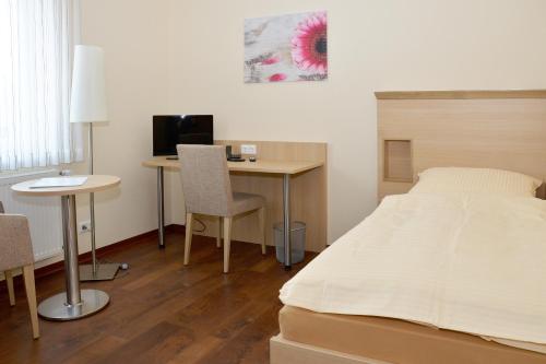 瓦伦霍尔斯特Gasthaus-Witte的一间卧室配有一张床和一张带电脑的书桌