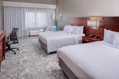 休斯顿Courtyard by Marriott Houston Medical Center/NRG Park的酒店客房配有两张床和一张书桌