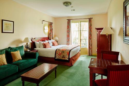 贝利罗曼维利而万豪度假巴黎省酒店的酒店客房,设有一张床铺和一张绿色沙发
