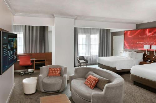 圣路易斯圣路易斯市中心万怡酒店/会议中心的酒店客房带一张床,卧室带一张床和椅子。