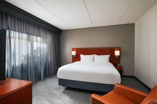 圣安东尼奥圣安东尼奥医学中心万豪万怡酒店的配有一张床和一把椅子的酒店客房