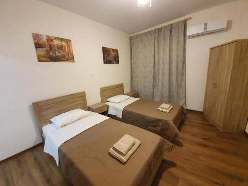 雅典City Center Athenes rooms的铺有木地板的小客房内的两张床