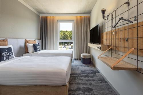 西梅尔恩Moxy Simmern的酒店客房设有两张床和电视。