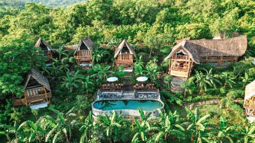 珀尼达岛Penida Bambu Green Suites的享有带游泳池的度假村的空中景致