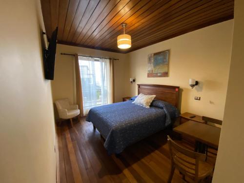 金特罗AH Rent的一间卧室配有一张床、一张书桌和一个窗户。