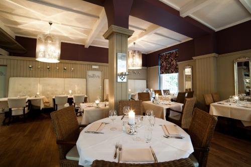 斯帕拉特内勒日酒店的一间设有白色桌椅的用餐室