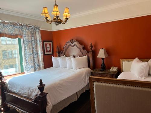 旧金山联合广场菲茨杰拉德酒店的一间卧室设有两张带橙色墙壁和吊灯的床。