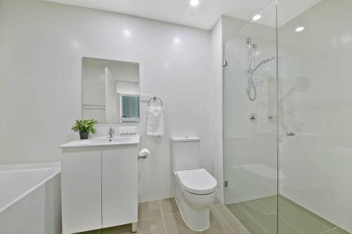 悉尼Aircabin｜Mascot｜Spacious & Modern｜Walk to station的白色的浴室设有卫生间和淋浴。
