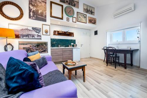罗维尼Loreto LYA SEA VIEW APARTMENTS的客厅配有紫色沙发和桌子