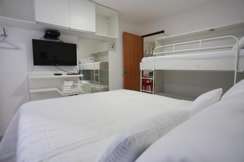 马塞约Maceio ferias apto completo a 100 metros da praia的白色卧室配有床和双层床