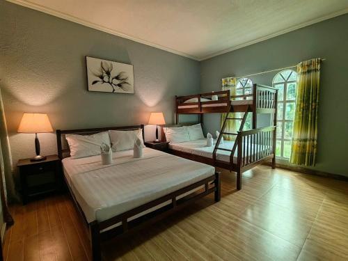 邦劳Coco Cabana Apartelle的一间卧室配有两张床和一张双层床。