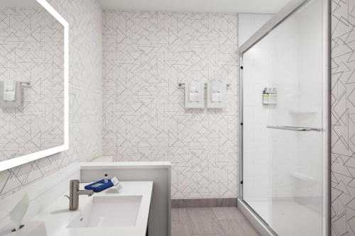 斯塔克Holiday Inn Express - Starke, an IHG Hotel的带淋浴和盥洗盆的白色浴室
