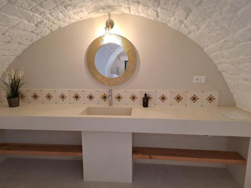 奥斯图尼Palazzo AD 1892 - SUITES & SPA的一间带水槽和镜子的浴室