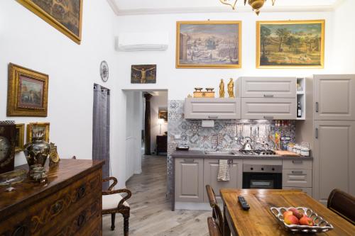 博洛尼亚casa Guido Reni的厨房配有白色橱柜和木桌