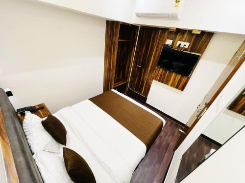 孟买Hotel Hilton Suites的一间卧室配有一张床和一台平面电视