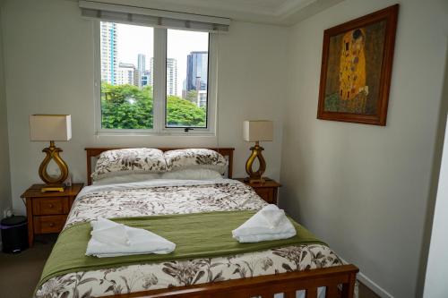 布里斯班City/Valley Resort Apartment的一间卧室设有一张床和一个美景窗户。