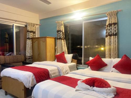 博卡拉Hotel Nightingale的酒店客房设有两张床和窗户。
