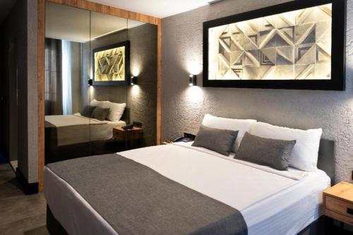 安塔利亚Mielo Lara Hotel的卧室配有一张白色大床和镜子