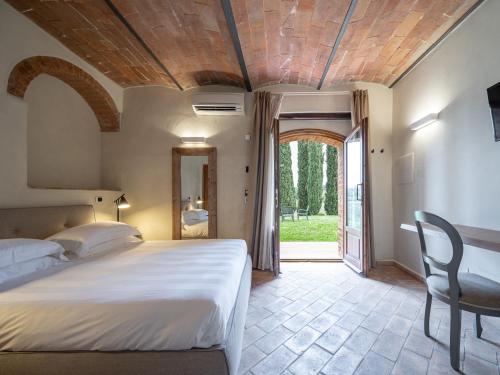 圣吉米纳诺Mormoraia的一间卧室配有一张床、一张桌子和一个窗户。