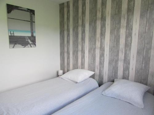 La CambeGîte de la Grenouille的卧室设有两张床,带条纹墙