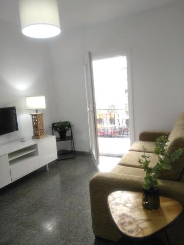 塞维利亚Sevilla Macarena apartamento 3 dormitorios的带沙发和电视的客厅