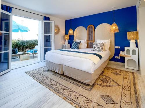 圣特罗佩乐莫伊拉格酒店的一间卧室配有一张带蓝色墙壁的大床